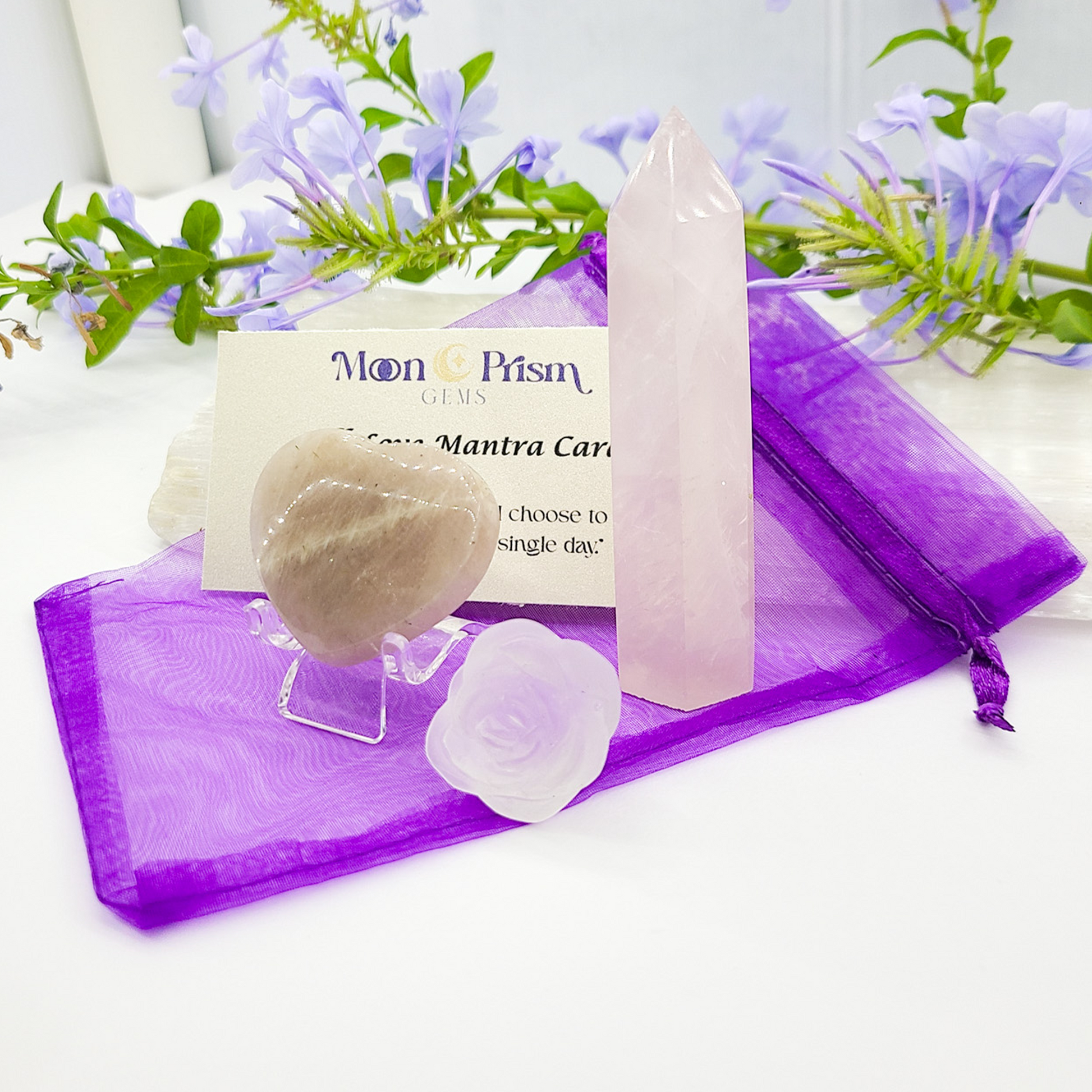 Crystal set with a card on a purple fabric, surrounded by flowers, with 'Moon Prism' branding.