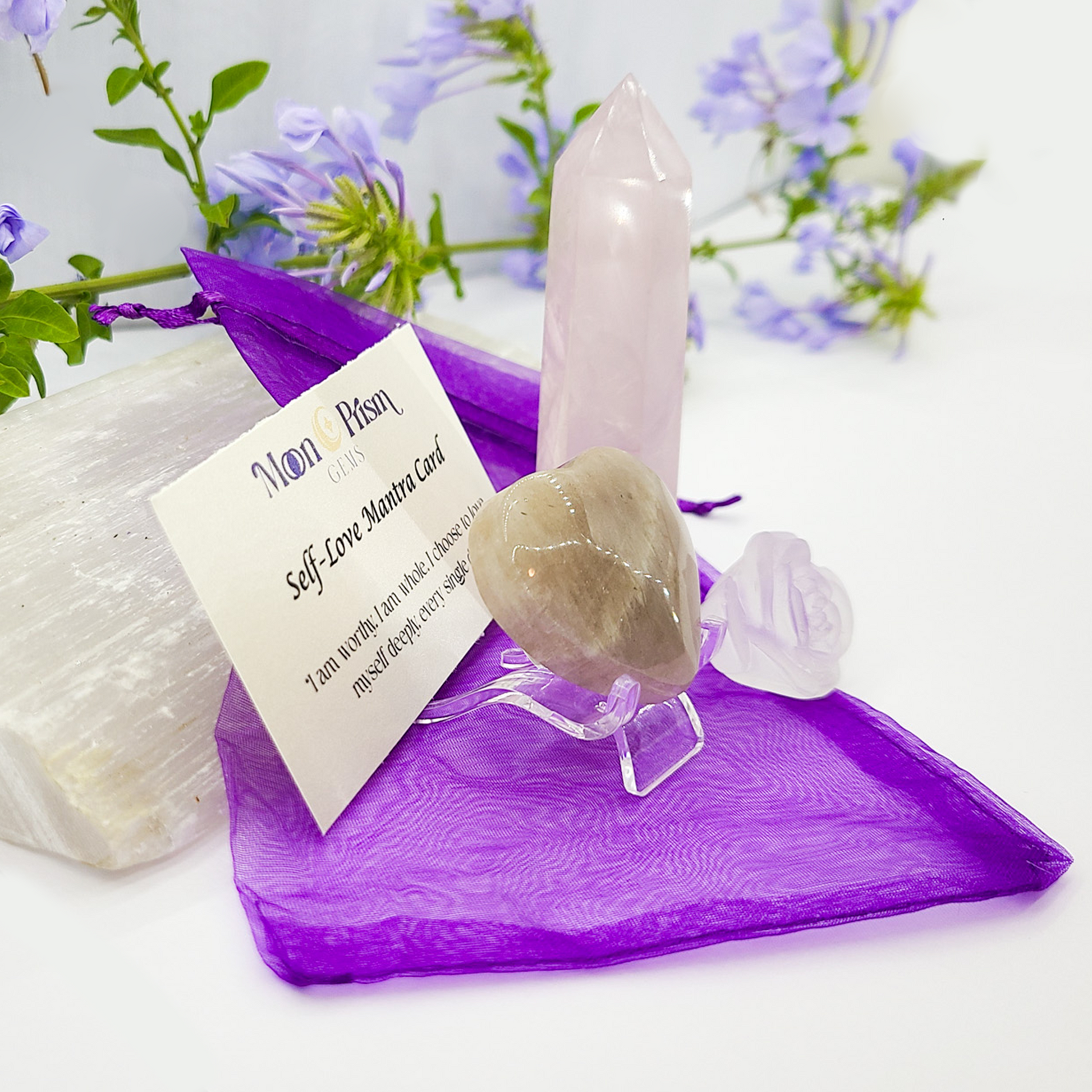 Crystal wand on a purple stand with a card and flowers in the background